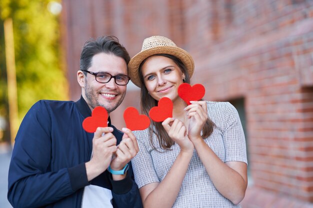 adult romantic couple holding hearts on the walk in the city