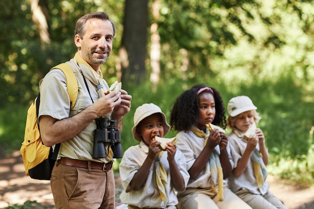 Photo adult scout leader smiling at camera during hiking trip