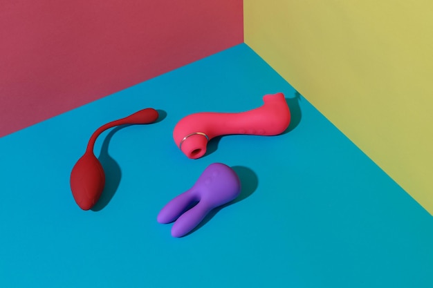 Adult sex toys such as dildo vibrator vacuum stimulator on colored background sex shop concept