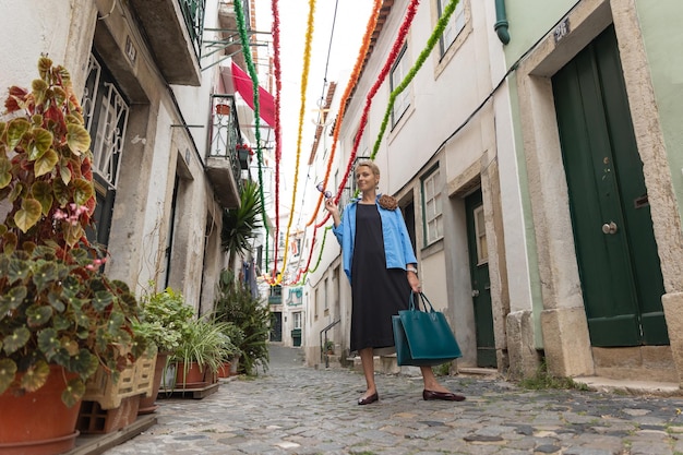 유럽 마을의 거리에 서 있는 성인 세련된 여성