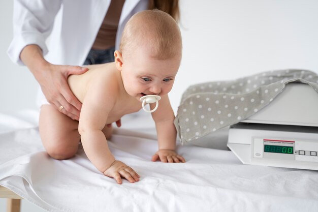 写真 赤ちゃんの体重管理をする大人