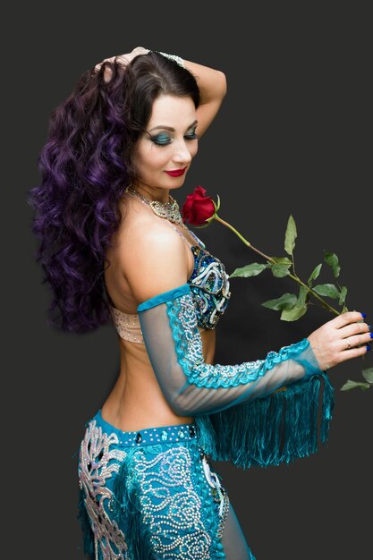 Adult woman dancer in a blue suit with a rose in her hands