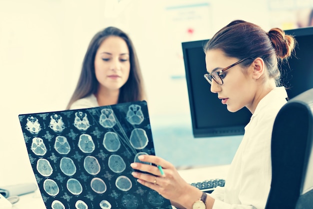 Photo adult woman discussing x-ray results during visit at female doctor's office