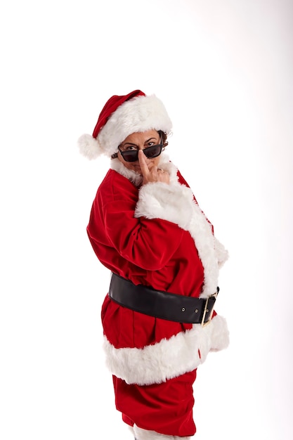 An adult woman dressed as Santa Claus looking at the camera with sunglasses.