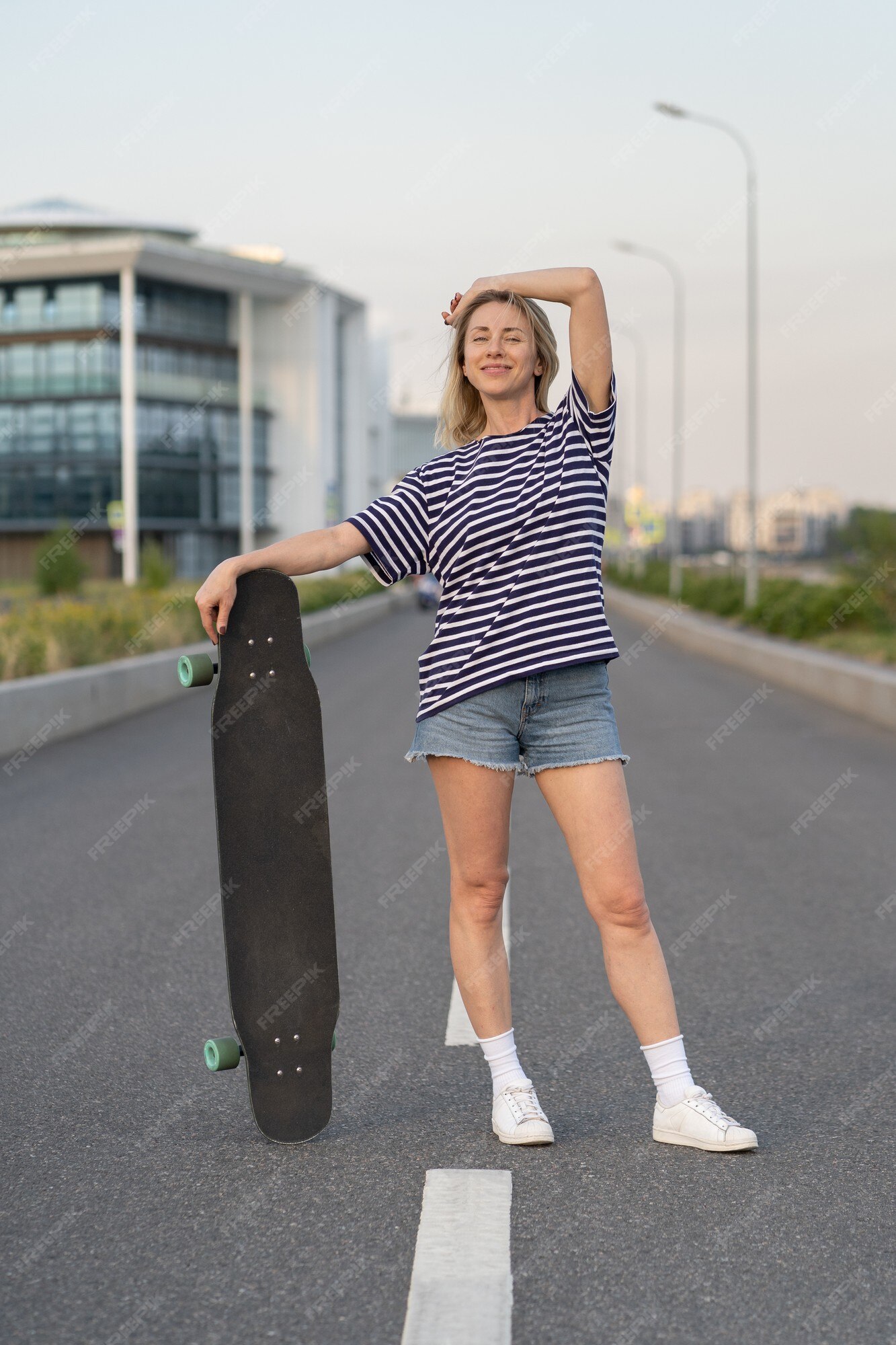 Premium Photo  Adult woman enjoy skating on longboard on empty city street  happy cheerful woman holding skateboard