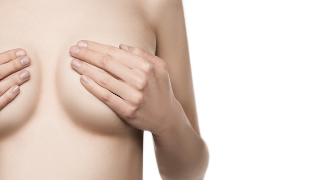 Adult woman examining breast for lumps, signs of breast cancer. 