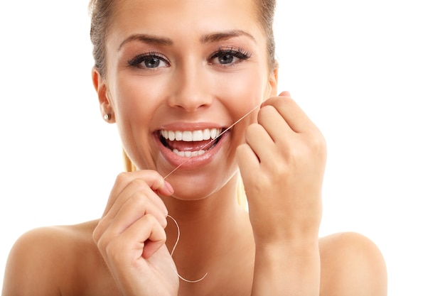 adult woman flossing her teeth isolated on white