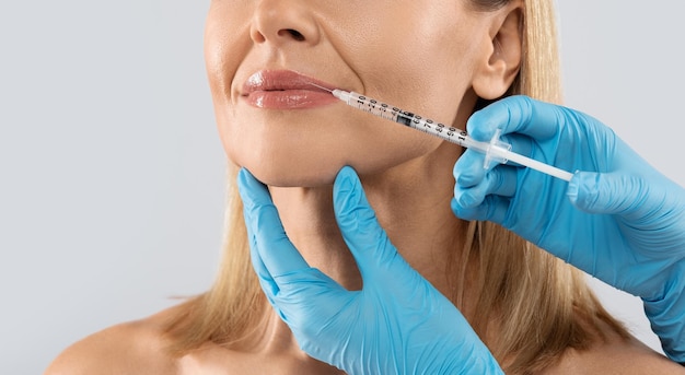 adult woman gets cosmetic injection in her lips cropped