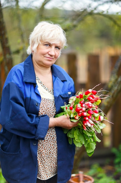 Взрослая женщина собирает урожай в теплице