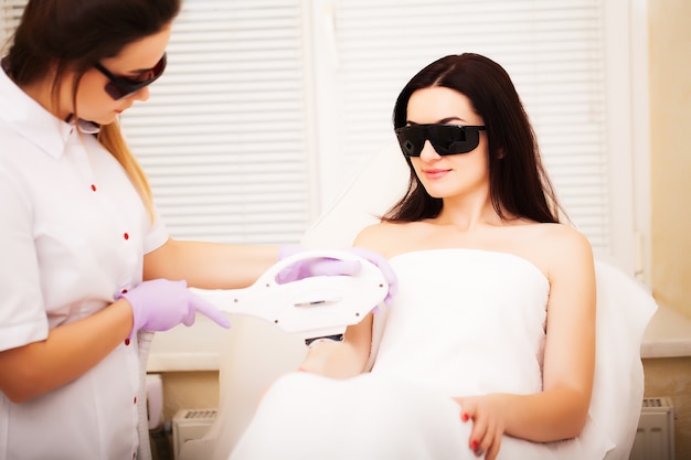 Photo adult woman having laser hair removal in professional beauty salon.