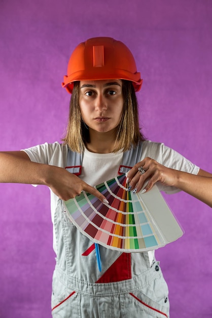 Adult woman holds color swatches with fan in hands chooses color isolated on plain background