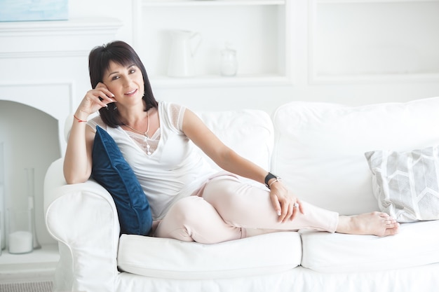 Adult woman interior portrait. Mature female indoors. Cheerful woman closeup portrait. Lady at home.