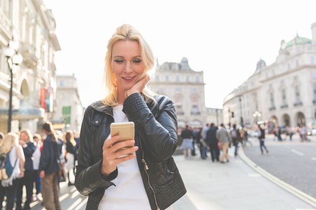 写真 ロンドンのスマートフォンを見て大人の女性