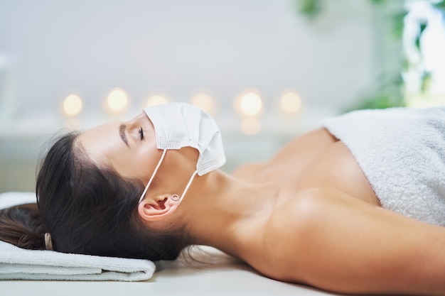 adult woman in mask during relaxing massage in spa