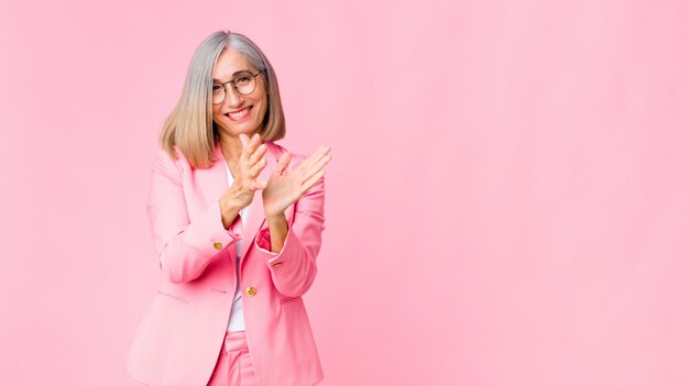 adult woman in pink suit clapping hands