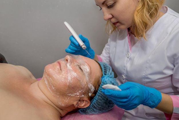 Adult woman in professional beauty spa during ultrasonic facial
cleansing procedure