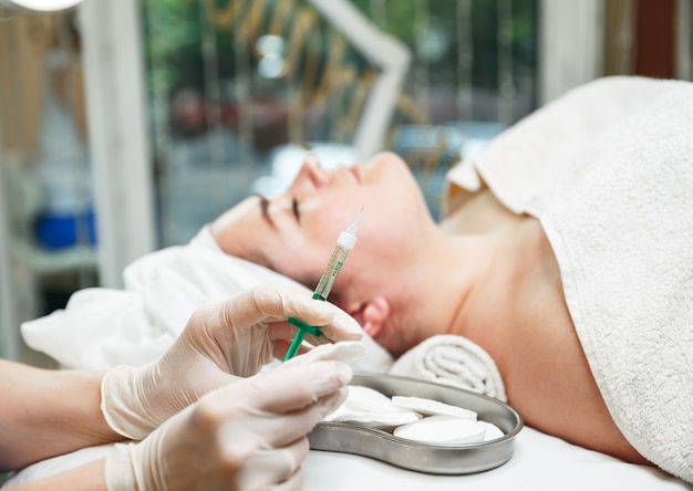 Photo adult woman receiving hyaluronic acid injection in a surgical clinic