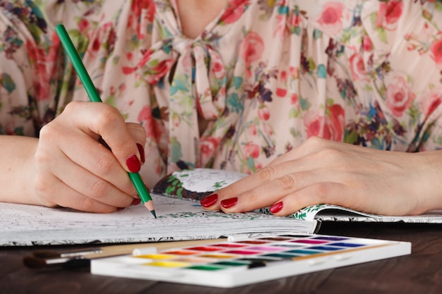 La donna adulta si rilassa facendo soffrire il libro da colorare