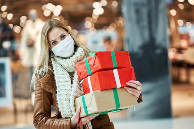 adult woman shopping in mall wearing a mask, coronavirus concept