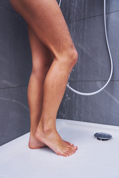 Adult woman under the shower in bathroom