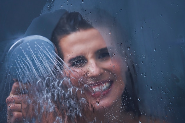 Adult woman under the shower in bathroom