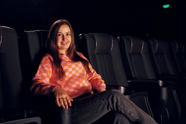 Photo adult woman sitting in the cinema and watching movie