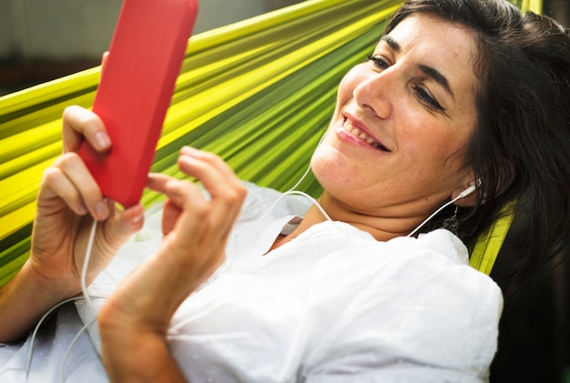 An Adult Woman Using Mobile Phone on a Hammock