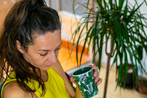 Foto una donna adulta con una tazza in mano si sta godendo l'atmosfera calda del suo spazio di copia a casa