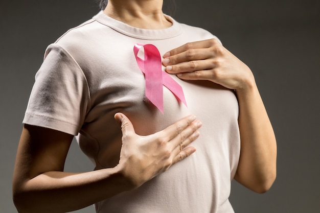 Adult woman with pink ribbon represent breast cancer awareness