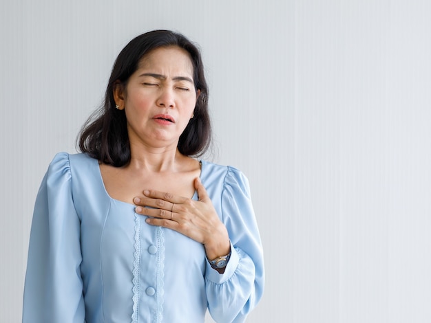 Adult woman with sudden heart attack and hold chest with pain face. Concept of emergency health care and affected from Congestive Failure or Cardiopulmonary Resuscitation, heart problem.