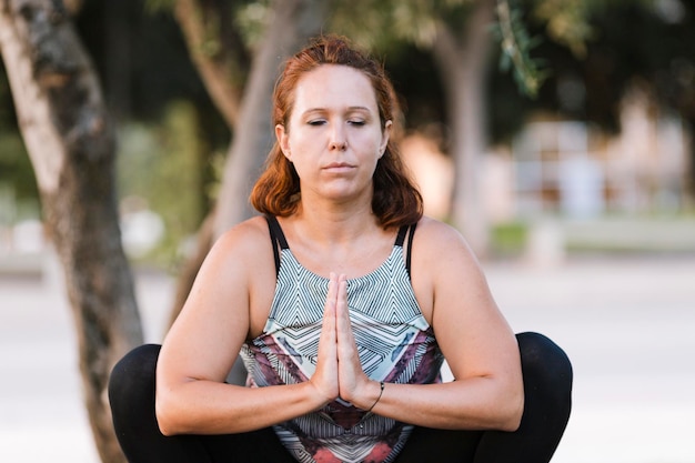Взрослая женщина в позе йоги с выражением концентрации