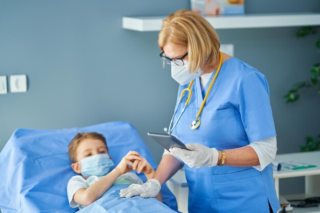 Adult woman and young patient in hospital bed. High quality photo