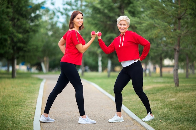 Adult women in sportswear exercising in the park