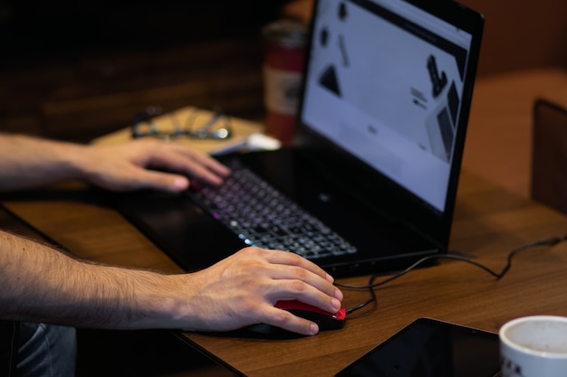 Adult young person typing and working on a laptop on the wood\
table