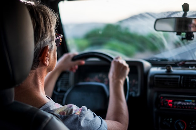 Adulta blanke dame rijdt en kijkt naar de weg vooruit