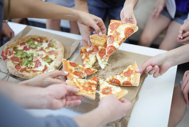 写真 大人と子供が箱にピザのスライスを乗せる