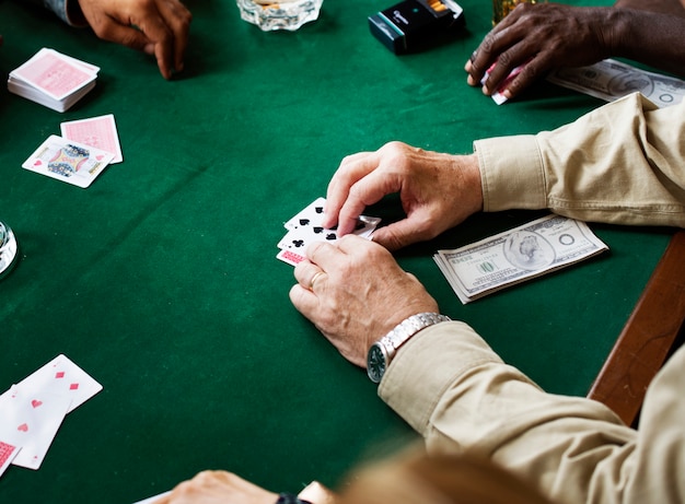 Photo adults socialising and playing cards