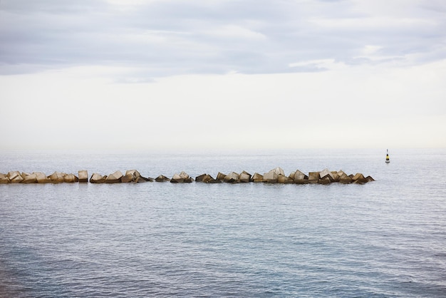 Foto muro marittimo avanzato nel frangiflutti che disegna l'orizzonte al tramonto sulla costa