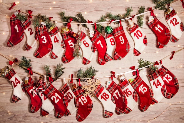 Adventskalender met cadeautjes in kindersokken takken van een kerstboom lichtjes van slingers