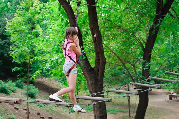 Adventure climbing high wire park - hiking in the rope park girl.