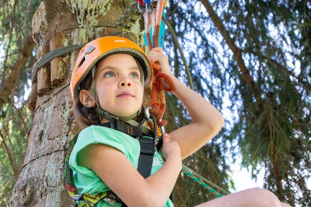 adventure climbing high wire park people on course in mountain helmet and safety equipment