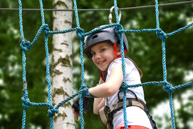 adventure climbing high wire park people on course in mountain helmet and safety equipment