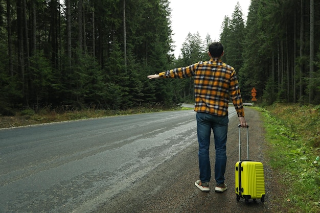 Adventure and tourism concept young man traveling by auto stop