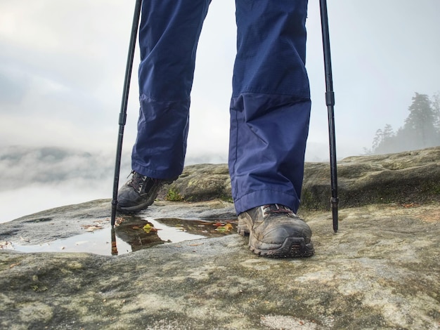Foto avventura donna escursione scarpe da trekking in azione su scivoloso sentiero di montagna vicino a scarpe da escursionista