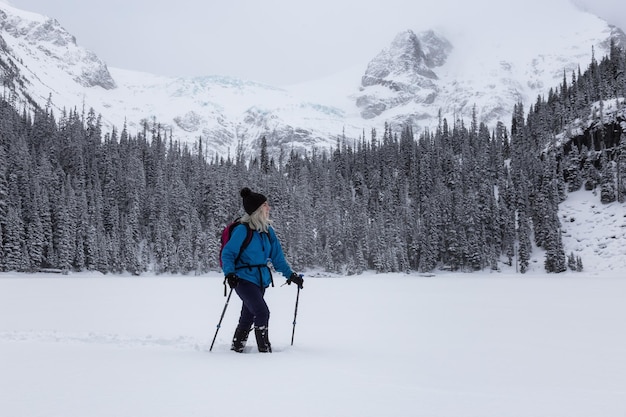 Adventure woman is hiking in the Canadian Snow Covered Landscape