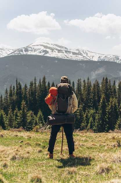 L'avventuriero è in piedi sul pendio della montagna verde