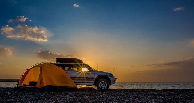 アドベンチャーキャンプ観光とテントと湖の隣の車。朝の屋外の風景