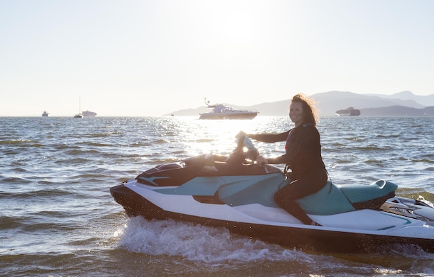 Предприимчивая кавказская женщина на водном скутере катается в океане