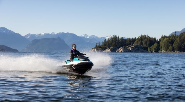 Adventurous caucasian woman on water scooter riding in the ocean