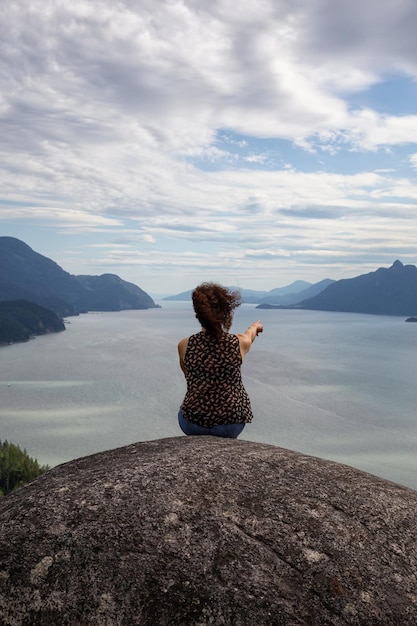 Adventurous Girl Hiking up a mountain during a vibrant summer day